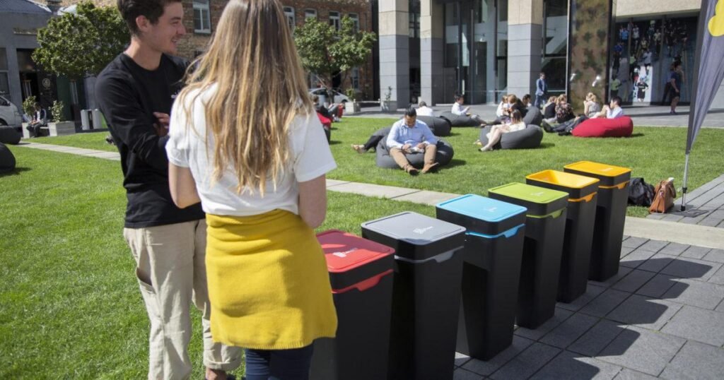 Color-coded recycling bins for paper, glass, plastic, and aluminum supporting environmental conservation in the USA.